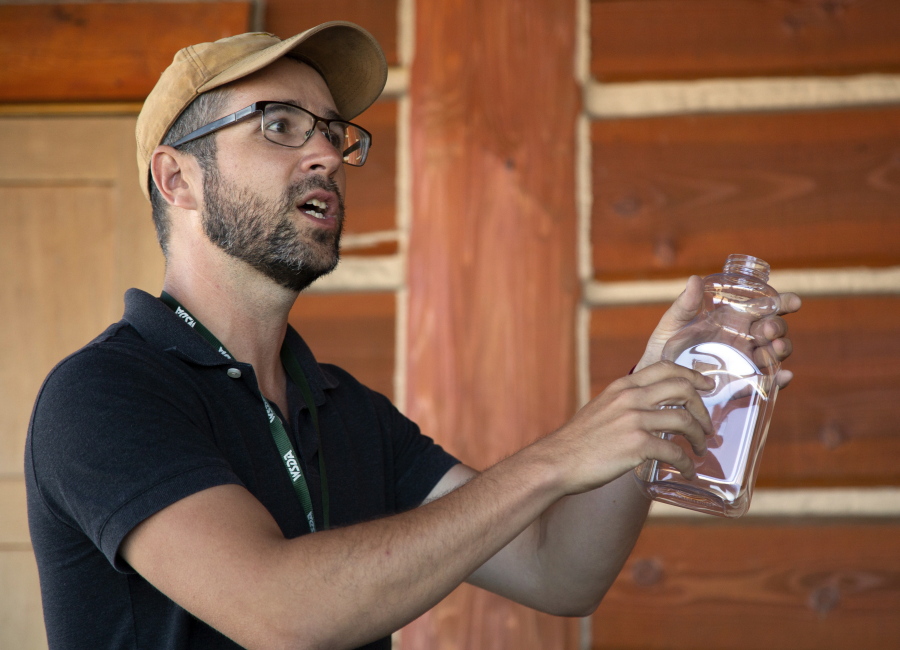 Asian giant hornet pest biologist Nathan Roueche holds a plastic bottle with a hole cut in the side that is used to trap the hornets, in Blaine, Wash., Tuesday, July 12, 2022. The Washington State Department of Agriculture hosted a tracking and trapping training session at Birch Bay State Park.
