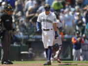 Seattle Mariners' Sam Haggerty drops his helmet and bat after he was out on a foul tip with the bases loaded to end the seventh inning. (Ted S.