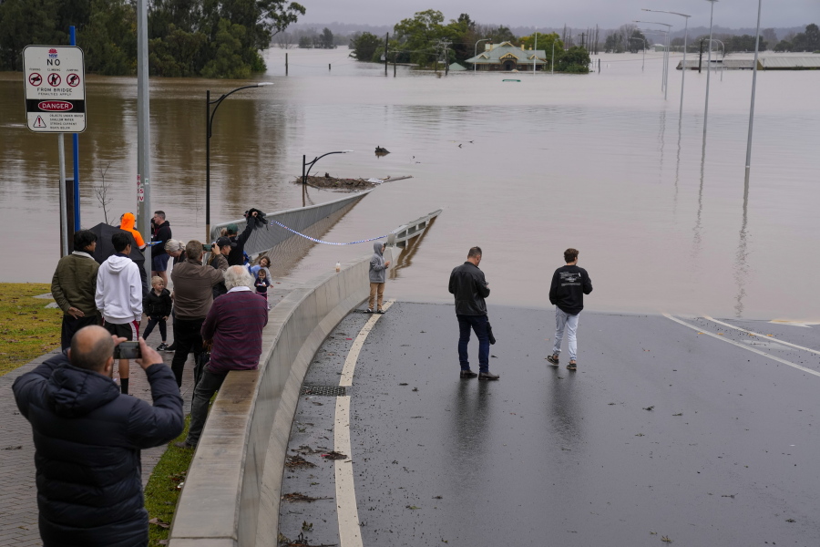 People look at the flooded Windsor Bridge at Windsor on the outskirts of Sydney, Australia, Tuesday, July 5, 2022.