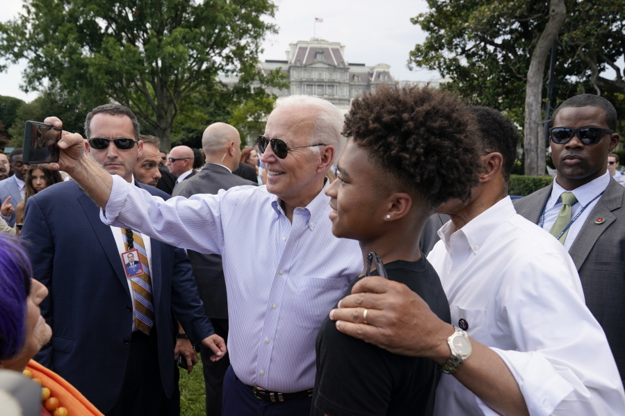 President Joe Biden poses for a photo with Rep. Kweisi Mfume, D-Md., and his grandson during the Congressional Picnic on the South Lawn of the White House, Tuesday, July 12, 2022, in Washington.