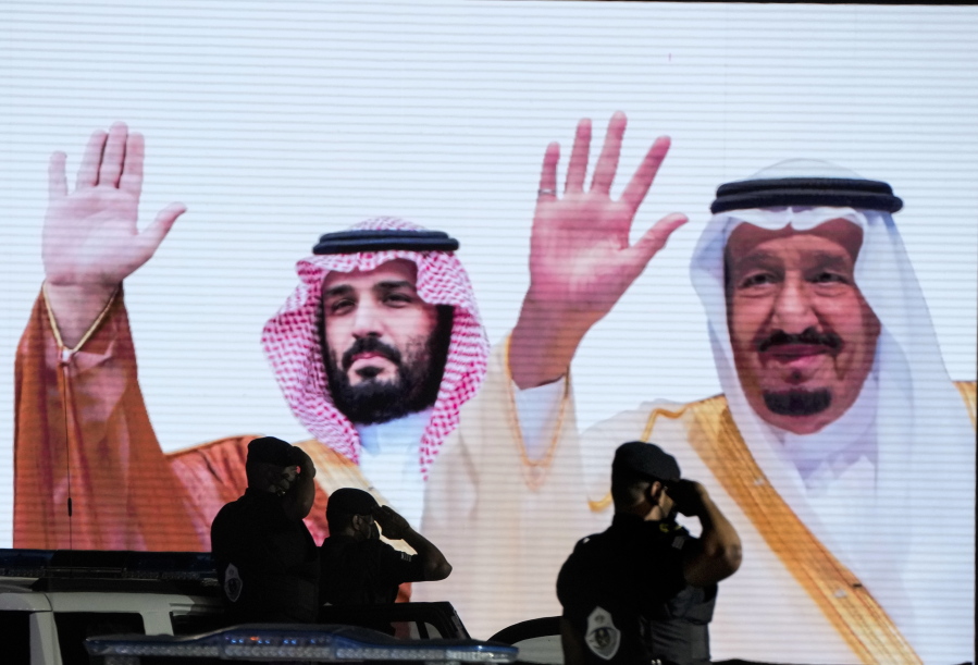 FILE - Saudi special forces salute in front of a screen displaying images Saudi King Salman, right, and Crown Prince Mohammed bin Salman after a military parade in preparation for the annual Hajj pilgrimage, in the Muslim holy city of Mecca, Saudi Arabia, July 3, 2022. President Joe Biden will become the first U.S. president to travel directly from Israel to Saudi Arabia. The world will be watching the highly anticipated meeting Friday to see if the gaffe-prone U.S. president and notoriously vengeful Saudi prince can begin repairing a rift between the two strategic partner.