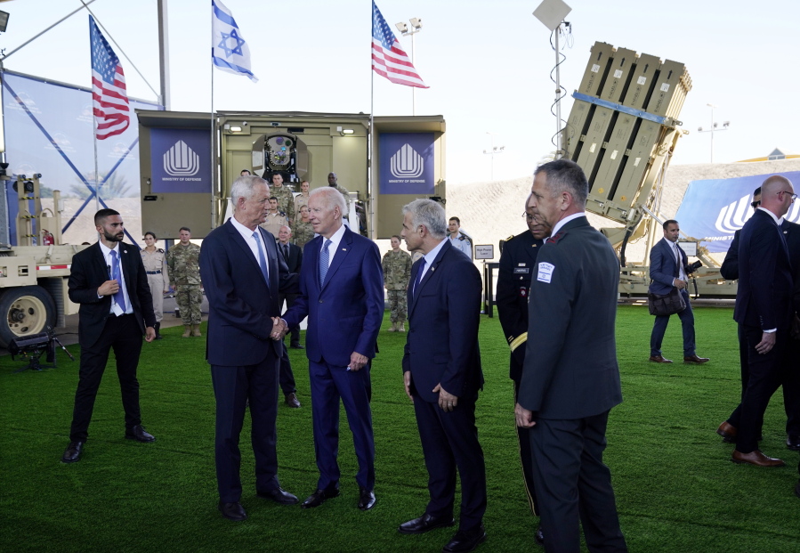 President Joe Biden shakes hands with Israeli Defense Minister Benny Gantz, as he is shown views of aerial defense systems, Wednesday, July 13, 2022, in Tel Aviv, as Israeli Prime Minister Yair Lapid, right of Biden, looks on.