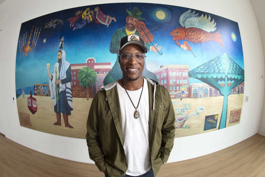 Nate Looney stands June 16 in front of a painting at the BAR Center at the Beach in the Venice section of Los Angeles. Looney is a Black man who grew up in Los Angeles, a descendant of enslaved people from generations ago. He's also an observant, kippah-wearing Jew. (Mark J.