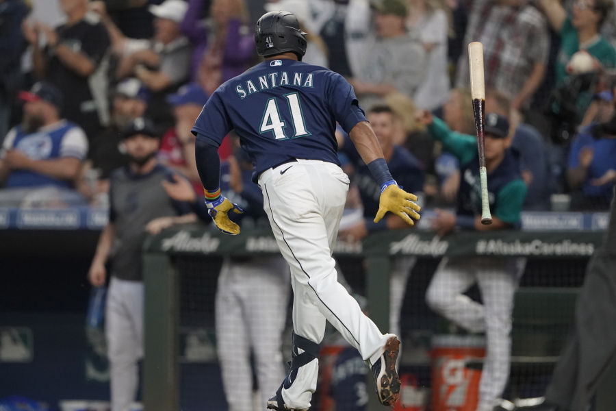 Seattle Mariners' Carlos Santana tosses his bat after he hit a two-run home run during the seventh inning of the team's baseball game against the Toronto Blue Jays, Saturday, July 9, 2022, in Seattle. (AP Photo/Ted S.