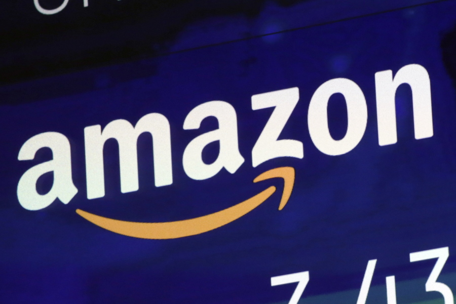 FILE  - The logo for Amazon is displayed on a screen at the Nasdaq MarketSite, July 27, 2018. Britain's competition watchdog is planning to investigate whether Amazon is harming competition and hurting consumers by giving an unfair advantage to merchants that pay for extra services.