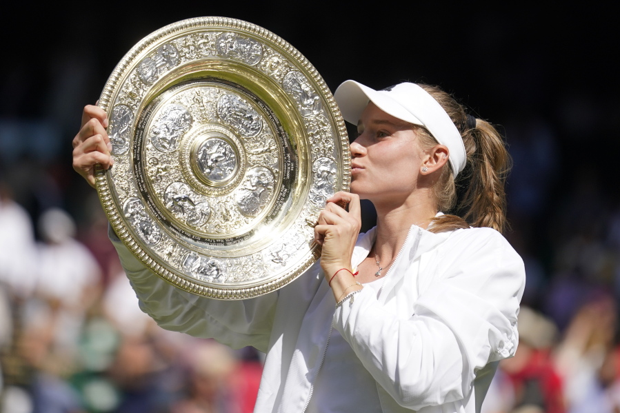 Kazakhstan's Elena Rybakina kisses the trophy as she celebrates after beating Tunisia's Ons Jabeur to win the final of the women's singles on day thirteen of the Wimbledon tennis championships in London, Saturday, July 9, 2022.