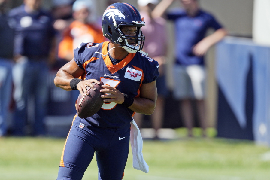 Denver Broncos quarterback Russell Wilson takes part in drills during the opening session of the NFL football team's training camp Wednesday, July 27, 2022, in Centennial, Colo.
