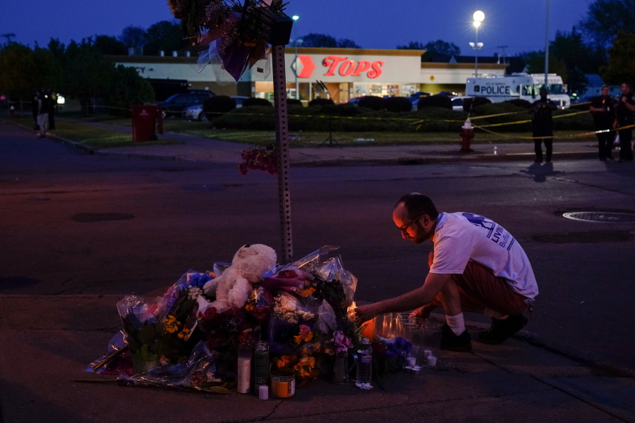 FILE - A person pays his respects outside the scene of a shooting at a supermarket, in Buffalo, N.Y., Sunday, May 15, 2022. The Tops Friendly Markets where 13 people were gunned down by a white gunman is set to reopen its doors Thursday, July 14 two months after the racist attack.