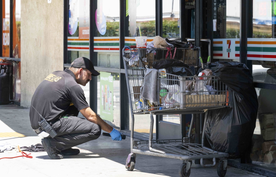 Officials investigate after officers found two victims with gunshot wounds following a robbery at a 7-Eleven in La Habra, Calif., on Monday, July 11, 2022.