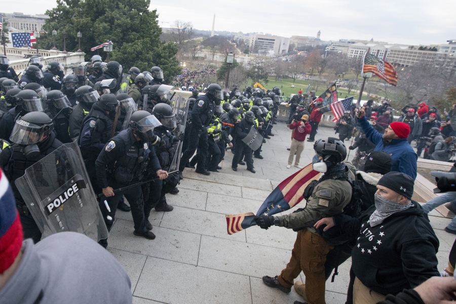 FILE - Rioters face off with police at the U.S. Capitol on Jan. 6, 2021, in Washington. A growing number of Capitol riot defendants are pushing to get their trials moved out of Washington. They claim they can't get a fair trial before unbiased jurors in the District of Columbia.