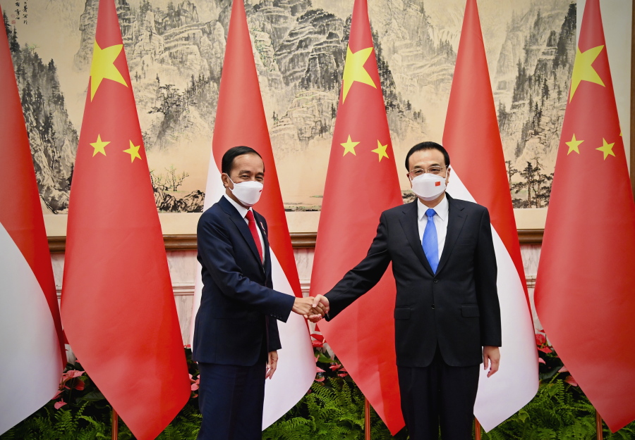 In this photo released by the Press and Media Bureau of the Indonesian Presidential Palace, Indonesian President Joko Widodo, left, shakes hands with Chinese Premier Li Keqiang during their meeting in Beijing, China, Tuesday, July, 26, 2022. Widodo arrived in Beijing on Monday night on the first stop of a trip that will also take him to Japan and South Korea later this week.