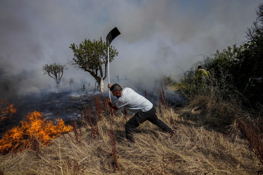 FILE - A local resident fights a forest fire with a shovel during a wildfire in Tabara, north-west Spain, July 19, 2022. Major wildfires in Europe are starting earlier in the year, becoming more frequent, doing more damage and getting harder to stop. And, scientists say, they're probably going to get worse as climate change intensifies unless countermeasures are taken.