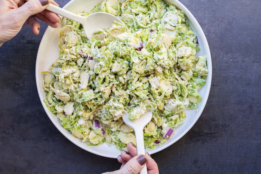 Creamy Brussels Sprouts Slaw with a mayonnaise-based dressing spiked with citrus juice, onions, mustard and Parmesan cheese.