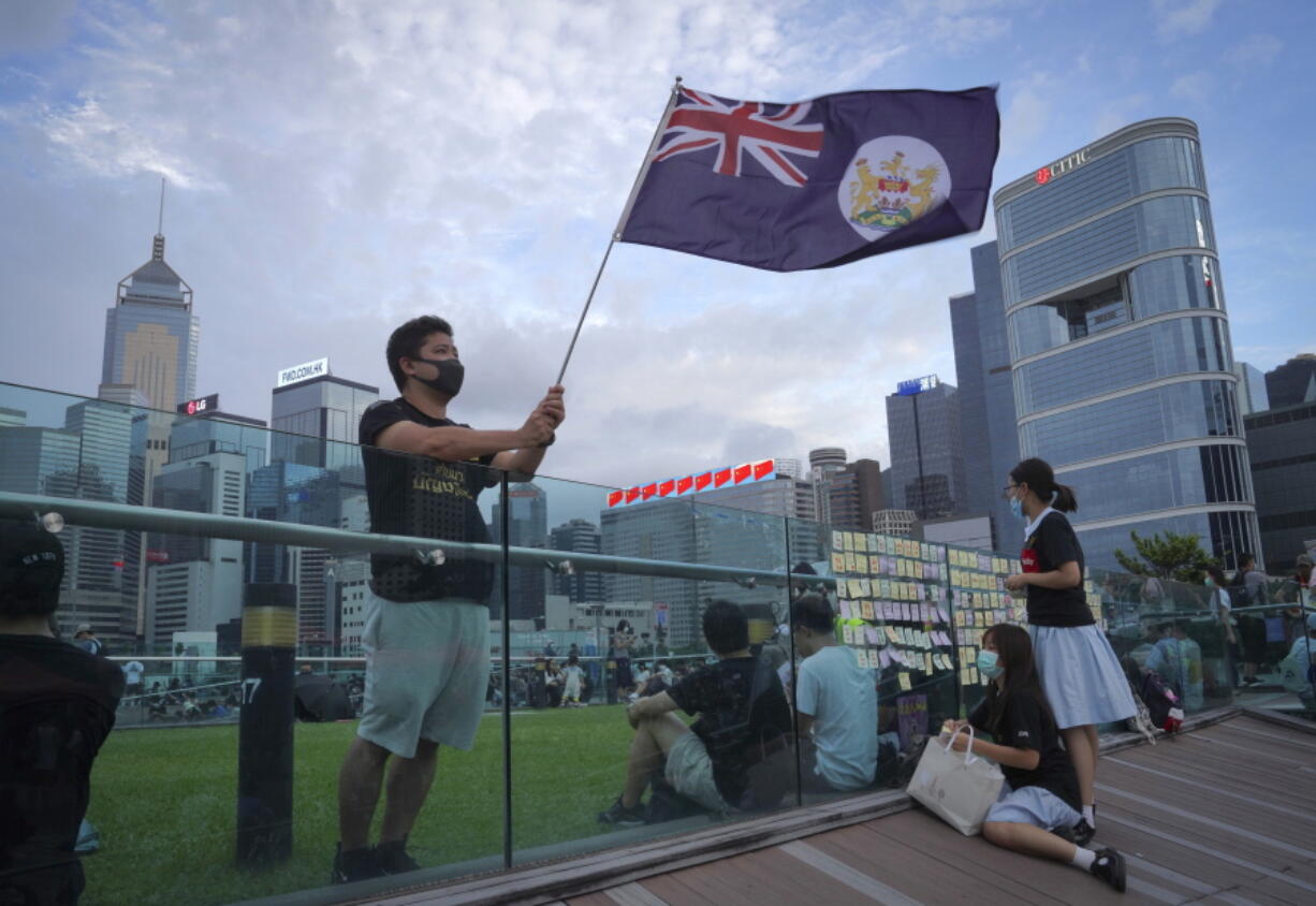 FILE - A protester waves Hong Kong British colony flag during continuing pro-democracy rallies in Tamar Park, Hong Kong, on Sept. 3, 2019. When the British handed its colony Hong Kong to Beijing in 1997, it was promised 50 years of self-government and freedoms of assembly, speech and press that are not allowed Chinese on the Communist-ruled mainland. As the city of 7.4 million people marks 25 years under Beijing's rule on Friday, those promises are wearing thin. Hong Kong's honeymoon period, when it carried on much as it always had, has passed, and its future remains uncertain, determined by forces beyond its control.