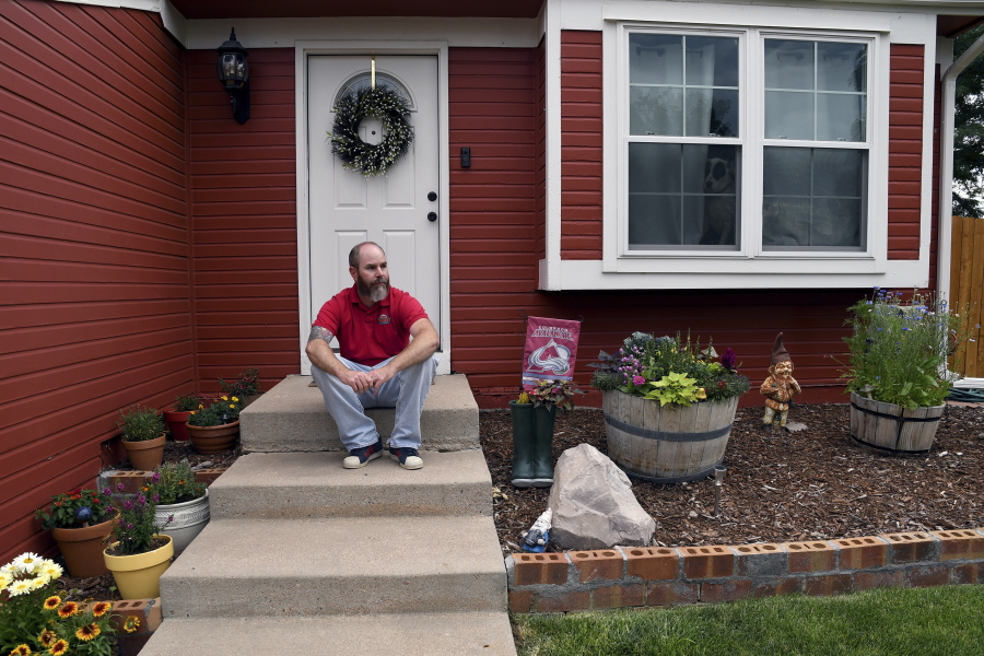 Kyle Tomcak sits in front of his house in Aurora, Colo., on Monday, July 18, 2022. Tomcak was in the market for a home priced around $450,000 for his in-laws and he and his wife bid on every house they toured, regardless of whether they fell in love with the home. He said his search became increasingly dispiriting as he not only lost out to investors fronting cash offers $100,000 over asking price but as mortgage rates started to balloon. He has since pulled out of the housing search.