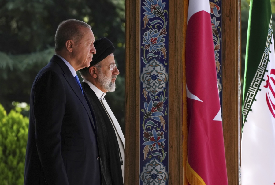Turkish President Recep Tayyip Erdogan, left, and his Iranian counterpart Ebrahim Raisi listen to their countries' national anthem during the welcoming ceremony at the Saadabad palace, in Tehran, Iran, Tuesday, July 19, 2022.