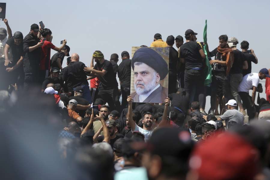 A protester holds a poster depicting Shiite cleric Muqtada al-Sadr on a bridge leading towards the Green Zone area in Baghdad, Iraq, Saturday, July 30, 2022 -- days after hundreds breached Baghdad's parliament Wednesday chanting anti-Iran curses in a demonstration against a nominee for prime minister by Iran-backed parties.(AP Photo/Anmar Khalil)
