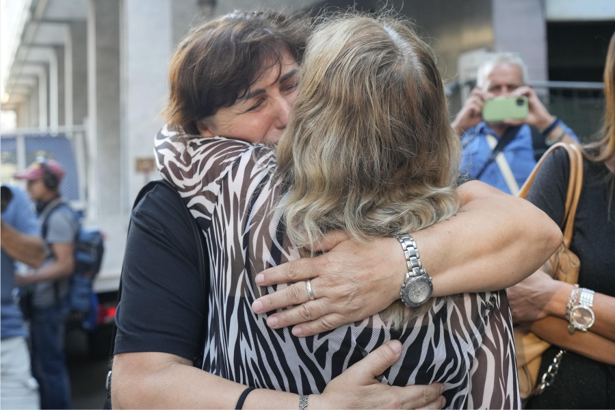 Maria Grazia Lonigro, right, and Mimosa Burkina, mothers of Luigi Matti Altadonna and Admir two of the 43 victims greet each other outside the Genoa's Palace of Justice on opening of the first hearing of the trial for the Morandi bridge collapse, Thursday, July 7, 2022. Forty-three people were killed when a large stretch of the Morandi Bridge broke off, August 14, 2018, on the eve of one of Italy's biggest vacation holidays.