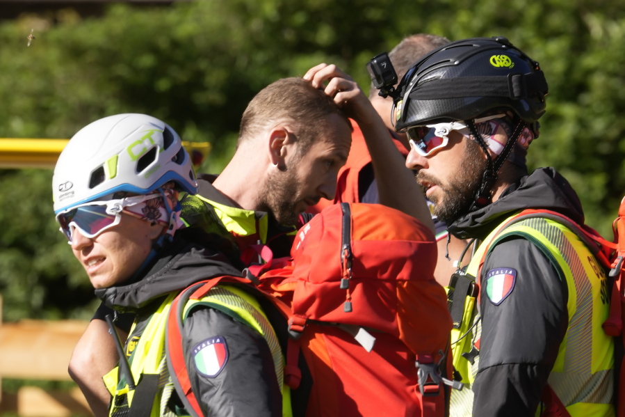 Rescuers prepare to conduct searches for the victims of the Punta Rocca glacier avalanche in Canazei, in the Italian Alps in northern Italy, Tuesday, July 5, 2022, two day after a huge chunk of the glacier broke loose, sending an avalanche of ice, snow, and rocks onto hikers.