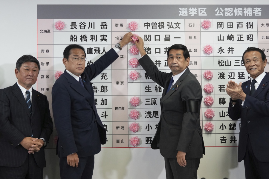 Fumio Kishida, second left, Japan's prime minister and president of the Liberal Democratic Party (LDP), speaks after placing a red paper rose on an LDP candidate's name, to indicate a victory in the upper house election, at the party's headquarters in Tokyo, Japan, on Sunday, July 10, 2022.