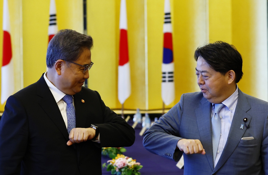 South Korean Foreign Minister Park Jin, left, and Japanese counterpart Yoshimasa Hayashi bump elbows before their talks in Tokyo, Monday, July 18, 2022.