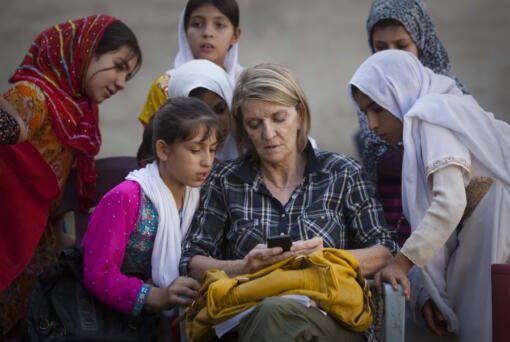 FILE - In this Saturday, Oct. 1, 2011 file photo, Associated Press Special Regional Correspondent for Afghanistan and Pakistan Kathy Gannon sits with girls at a school in Kandahar, Afghanistan.