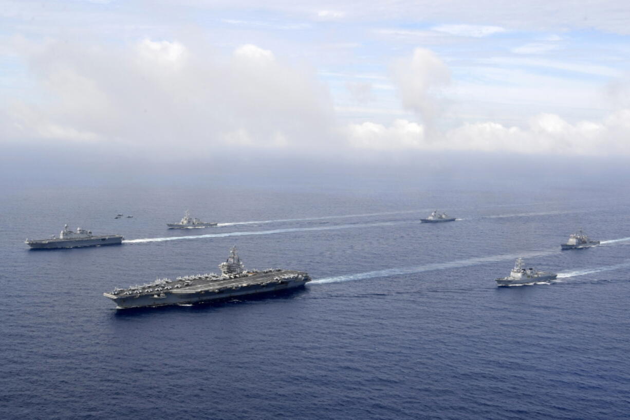 FILE - In this photo provided by South Korea's Defense Ministry, U.S. nuclear-powered aircraft carrier USS Ronald Reagan, second from left, and South Korea's landing platform helicopter (LPH) ship Marado, left, sail during a joint military exercise at an undisclosed location, June 4, 2022.