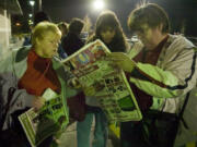 Judi Church, left, Susie Weisel and Judi's sister Tracy Manlow, right, double check the Fred Meyer newspaper insert as they wait in line before dawn on Black Friday in November 2017.
