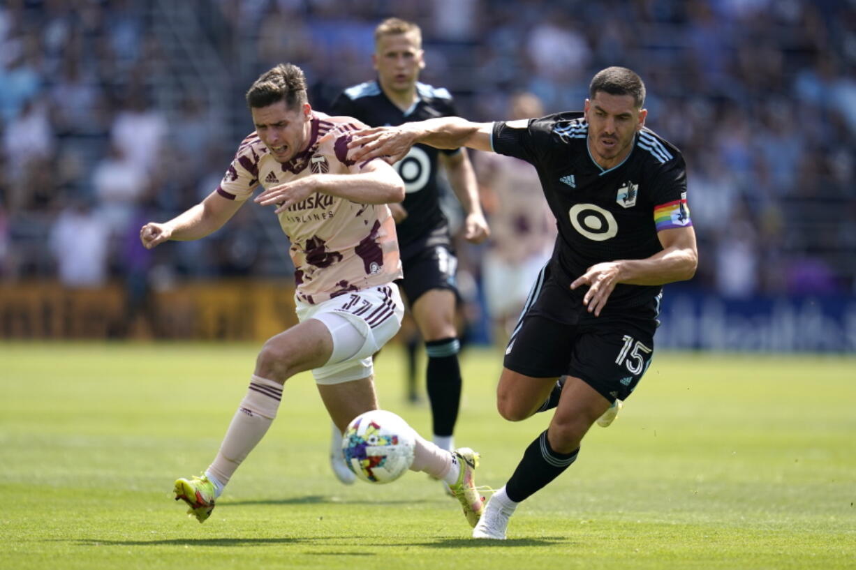 Portland Timbers forward Jaros?aw Niezgoda (11) and Minnesota United defender Michael Boxall (15) battle for possession during the second half of an MLS soccer match at Allianz Field in Saint Paul, Minn., Saturday, July 30, 2022.