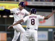 Houston Astros' Alex Bregman, left, celebrates his two-run home run against the Seattle Mariners with third base coach Gary Pettis during the first inning of a baseball game Thursday, July 28, 2022, in Houston.