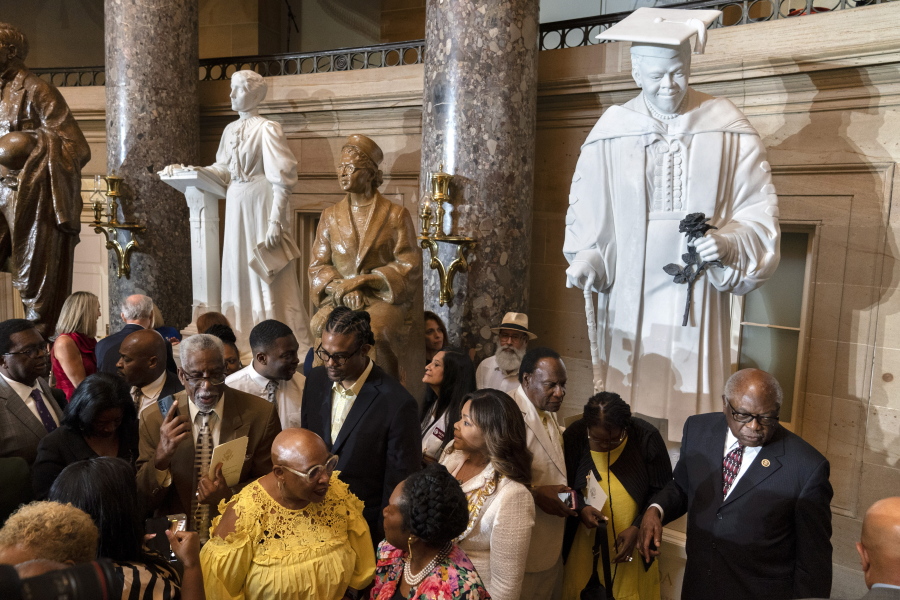 Evelyn Bethune, front left in yellow, a granddaughter of Mary McLeod Bethune, speaks with Rep. Sheila Jackson Lee, D-Texas, as members of the Congressional Black Caucus gather around an unveiled statue of Mary McLeod Bethune, at a ceremony for the statue, which is the first state statue of a Black woman in Statuary Hall, Wednesday, July 13, 2022, at the U.S. Capitol in Washington. Rep. James Clyburn, D-S.C., is at front right.