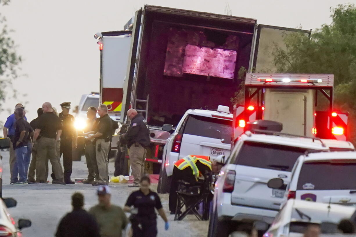 FILE - Police and other first responders work the scene where officials say dozens of people have been found dead and multiple others were taken to hospitals with heat-related illnesses after a semitrailer containing suspected migrants was found, Monday, June 27, 2022, in San Antonio. Following the horror of 53 migrants found dead or dying in Texas. The deadliest smuggling attempt in U.S. history illustrated the limitations of Texas Gov. Greg Abbott's massive border apparatus after 53 migrants were found dead or dying in a tractor-trailer in San Antonio.