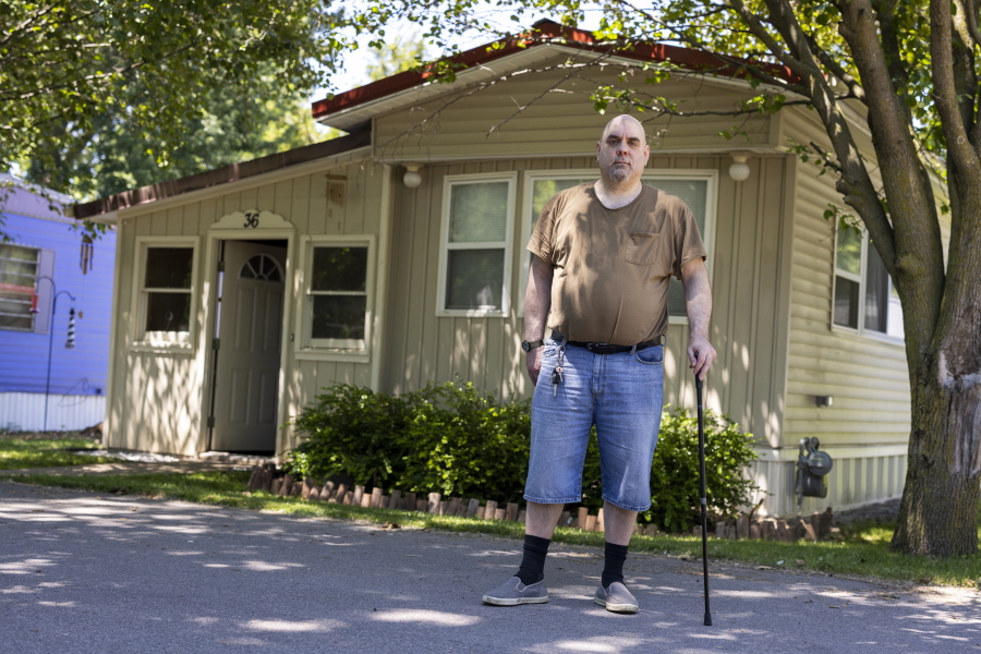Jeremy Ward poses for a portrait in front of his home in the Ridgeview Homes mobile home community in Lockport, N.Y., June 23, 2022. Ward is one of the residents at Ridgeview participating in a rent strike after new owners of the park announced they were raising rents by six percent. "I moved here because it's basically the most affordable living," said Ward, who is disabled and living off of a fixed income. The plight of residents at Ridgeview is playing out nationwide as institutional investors, led by private equity firms and real estate trusts and sometimes funded by pension funds, swoop in to buy mobile home parks.