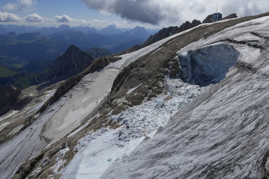 A view taken from a rescue helicopter of the Punta Rocca glacier near Canazei, in the Italian Alps in northern Italy, Tuesday, July 5, 2022, two days after a huge chunk of the glacier broke loose, sending an avalanche of ice, snow, and rocks onto hikers. Italy was enduring a prolonged heat wave before a massive piece of the Alpine glacier broke off and killed hikers on Sunday and experts say climate change will make those hot, destabilizing conditions more common.