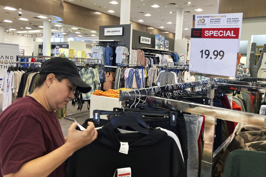 A customer checks price tags as she shops at a retail store in Schaumburg, Ill., Thursday, June 30, 2022. (AP Photo/Nam Y.