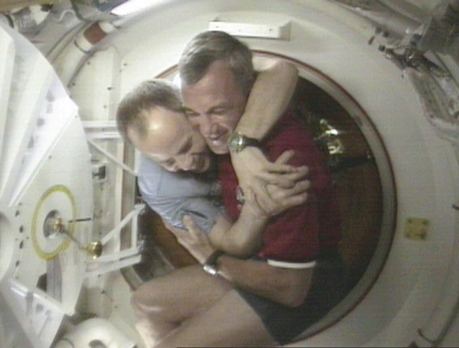 FILE - Shuttle Commander Terrence Wilcutt, right, and Mir Commander Anatoly Solovyev, left, hug after opening the hatches between the space shuttle Endeavour and the Russian Space station Mir Saturday, Jan. 24, 1998 in this image from television. Russia will opt out of the International Space Station after 2024 and focus on building its own orbiting outpost, the country's newly appointed space chief said Tuesday, July 26, 2022.