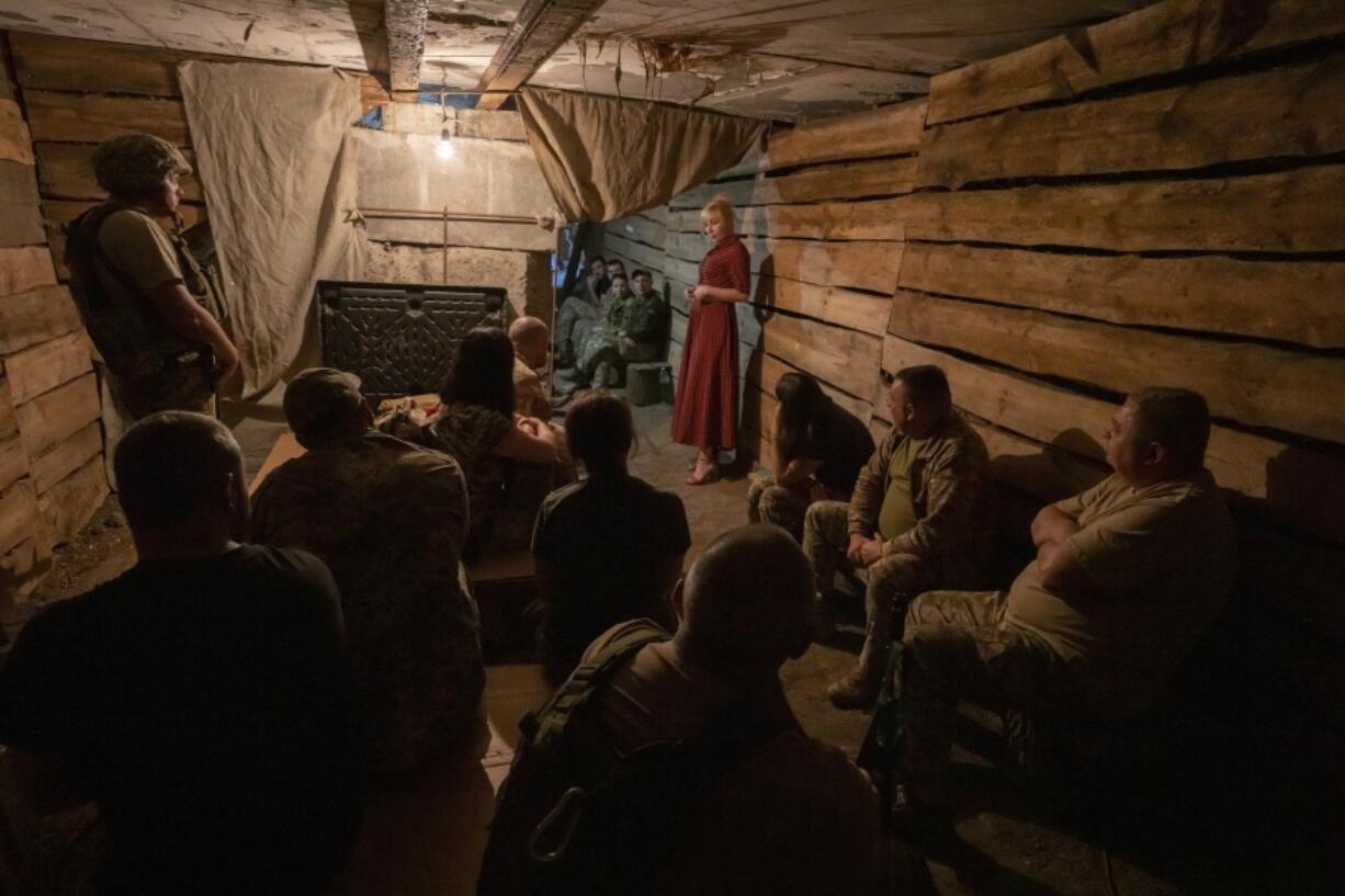 Medic volunteer Nataliia Voronkova, top right, gives a medical tactical training session to soldiers in a bomb shelter as air raid sirens go off, in Dobropillia, eastern Ukraine, Friday, July 22, 2022. Voronkova has dedicated her life to aid distribution and tactical medical training for soldiers and paramedics, working on front line of the Donetsk region since the war began in 2014.