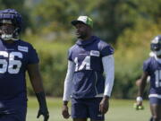 Seattle Seahawks wide receiver DK Metcalf, center, stands on the field during NFL football training camp Thursday, July 28, 2022, in Renton, Wash. (AP Photo/Ted S.