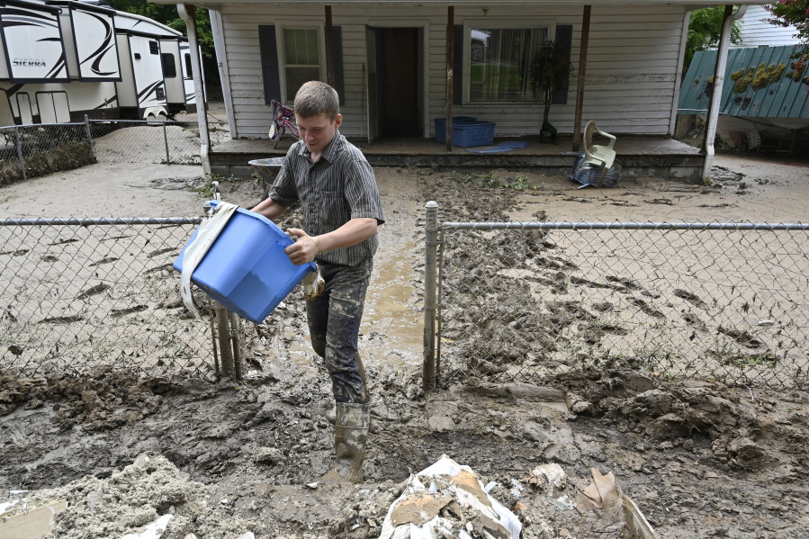 Members of the local Mennonite community remove mud filled debris from homes following flooding at Ogden Hollar in Hindman, Ky., Saturday, July 30, 2022. (AP Photo/Timothy D.