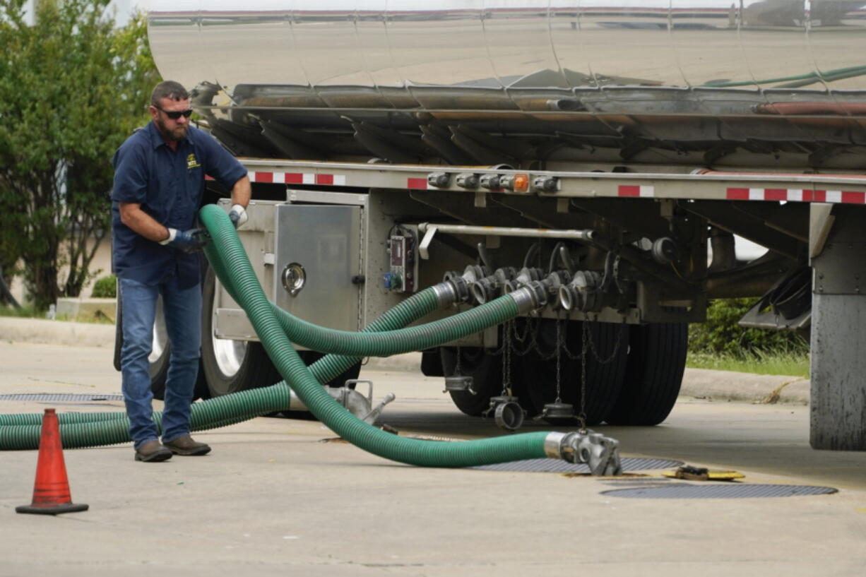 FILE - A gas tank driver adjusts his hose hookup to an underground tank on May 24, 2022, in Jackson, Miss. High diesel prices are driving up the cost of most goods, from groceries to Amazon orders and furniture, as nearly everything that is delivered, whether by truck, rail or ship, uses diesel fuel. Truckers are turning down hauling jobs in the states with the most expensive diesel. (AP Photo/Rogelio V.
