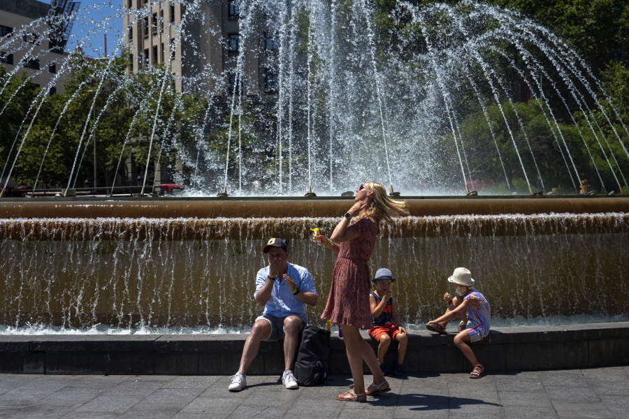A family apply sunscreen to protect themselves from the sun on a hot and sunny day in Barcelona, Spain, Friday, July 15, 2022.