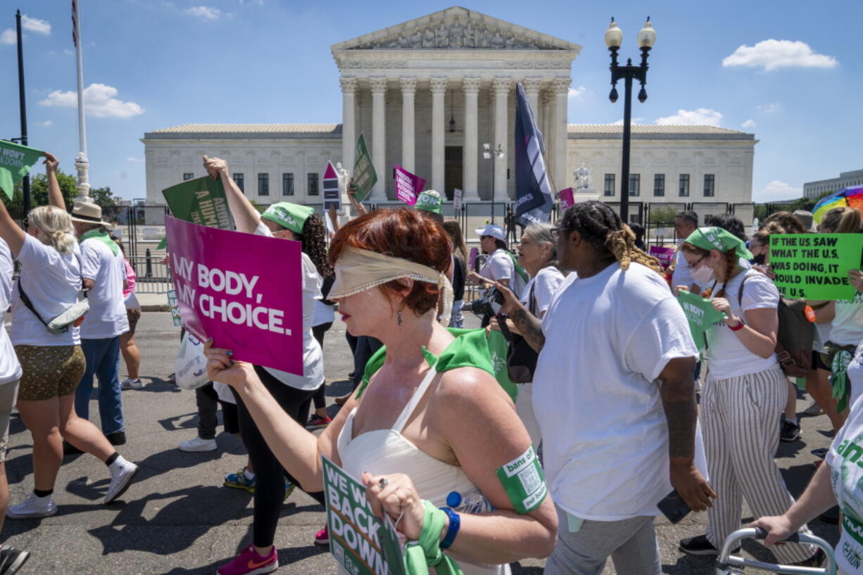 Mahayana Landowne, of Brooklyn, N.Y., wears a "Lady Justice" costume as she marches past the Supreme Court during a protest for abortion-rights, Thursday, June 30, 2022, in Washington.