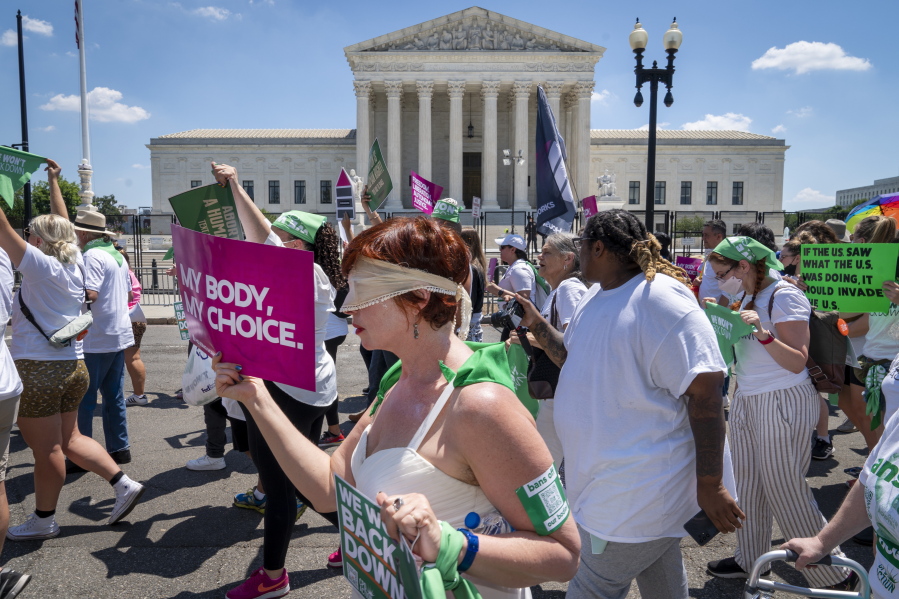 Mahayana Landowne, of Brooklyn, N.Y., wears a "Lady Justice" costume as she marches past the Supreme Court during a protest for abortion-rights, Thursday, June 30, 2022, in Washington.