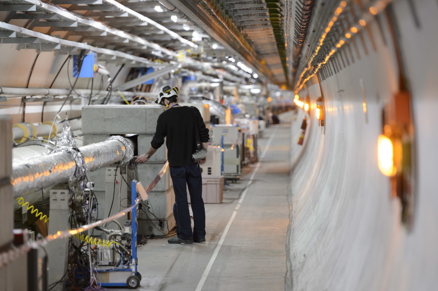 FILE - A technician works in the LHC (Large Hadron Collider) tunnel of the European Organization for Nuclear Research, CERN, during a press visit in Meyrin, near Geneva, Switzerland, Feb. 16, 2016. The physics lab that's home to the world's largest atom smasher announced on Tuesday, July 5, 2022 the observation of three new "exotic particles" that could provide clues about the force that binds subatomic particles together. The observation of a new type of pentaquark and the first duo of tetraquarks at CERN, the Geneva-area home to the LHC, offers a new angle to assess the so-called "strong force" that holds together the nuclei of atoms.