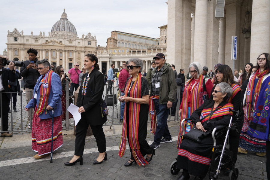 FILE - President of the Metis community, Cassidy Caron, second left, and other delegates arrive to speak to the media in St. Peter's Square after their meeting with Pope Francis at The Vatican, March 28, 2022. Pope Francis' trip to Canada, which begins Sunday July 24, 2022, to apologize for the horrors of church-run Indigenous residential schools marks a radical rethink of the Catholic Church's missionary legacy in the Americas, spurred on by the first American pope and the discovery of hundreds of unmarked graves at the school sites.