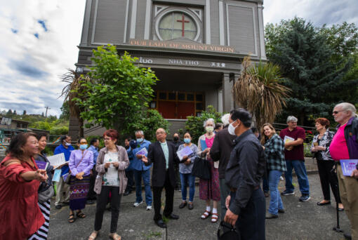 Parishioners who refuse to abandon their locked-up Our Lady of Mount Virgin Catholic Church converse after a service without Mass held on the sidewalk July 17 in Seattle's Mount Baker neighborhood.