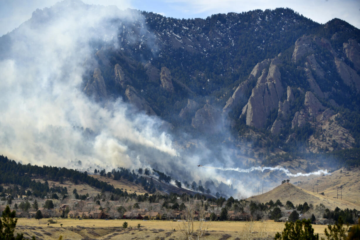 In this photo from March 26, 2022, a single-engine air tanker drops water on the NCAR fire as it burns in the foothills south of the National Center for Atmospheric Research in Boulder, Colorado. The NCAR fire prompted evacuations in south Boulder and a pre-evacuation warning for Eldorado Springs. The wildfire broke out near the National Center for Atmospheric Research in southwestern Boulder on Saturday afternoon, prompting evacuation orders for parts of the city and pre-evacuation notices for Eldorado Springs, according to authorities. Boulder police initially said about 1,200 residences had been ordered to evacuate due to what has been named the NCAR fire. But a short time later, police tweeted a map that showed nearly all of south Boulder under evacuation. The Boulder Office of Emergency Management now says that the map was wider than required and that the actual evacuation area is "from NCAR to Baseline Road, east to U.S. 36, back down to Broadway, and straight west to NCAR again." (Helen H.