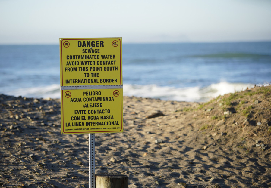 In this file photo, contaminated water signs are posted along the southern part of the beach in Imperial Beach, California.