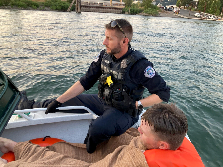 A Vancouver police officer with a man who was arrested Wednesday evening. Police say the man ran from them and jumped into the Columbia River.