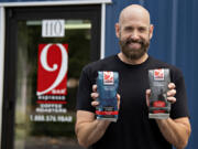 Coffee entrepreneur Corey Schmidt holds two sacks of his specialty roasts outside 9 Bar Espresso in Vancouver.